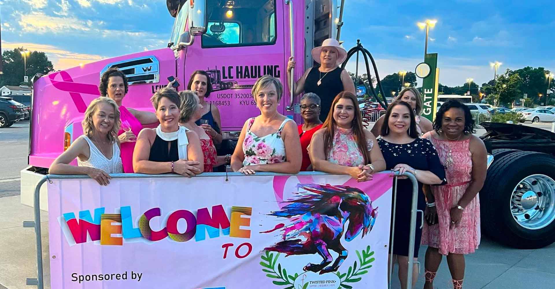 Women standing in front of pink LC Hauling truck raising awareness for breast cancer